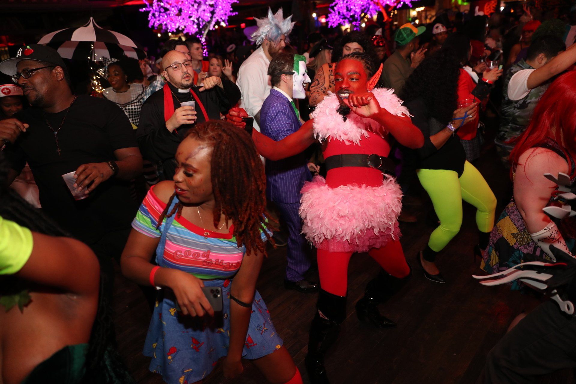 A group of people dressed in costumes are dancing at a party.