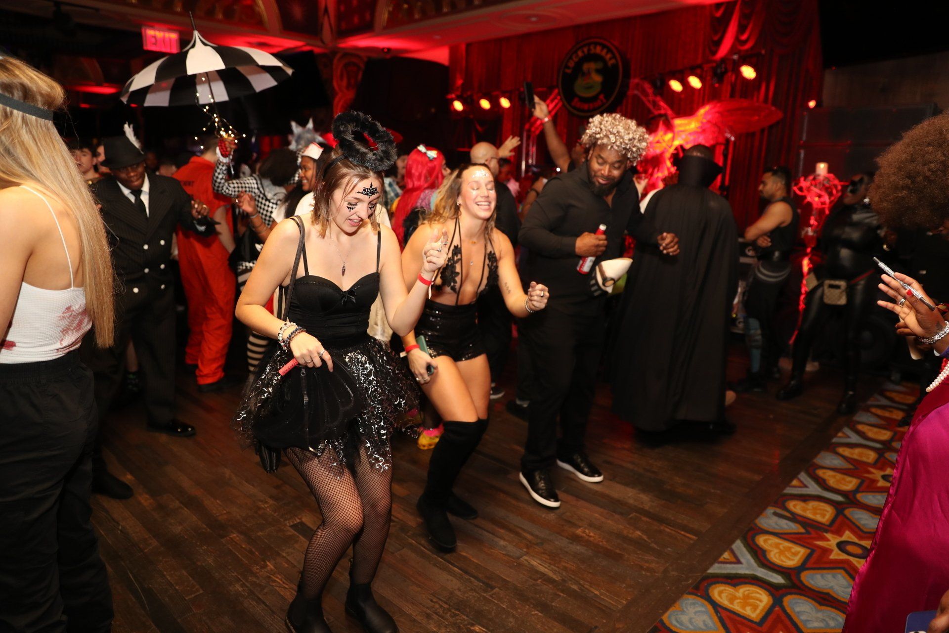A group of people are dancing at a halloween party.
