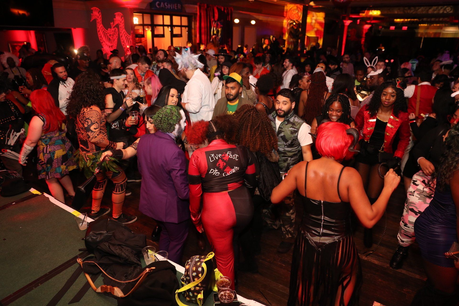 A large group of people are dancing at a halloween party.