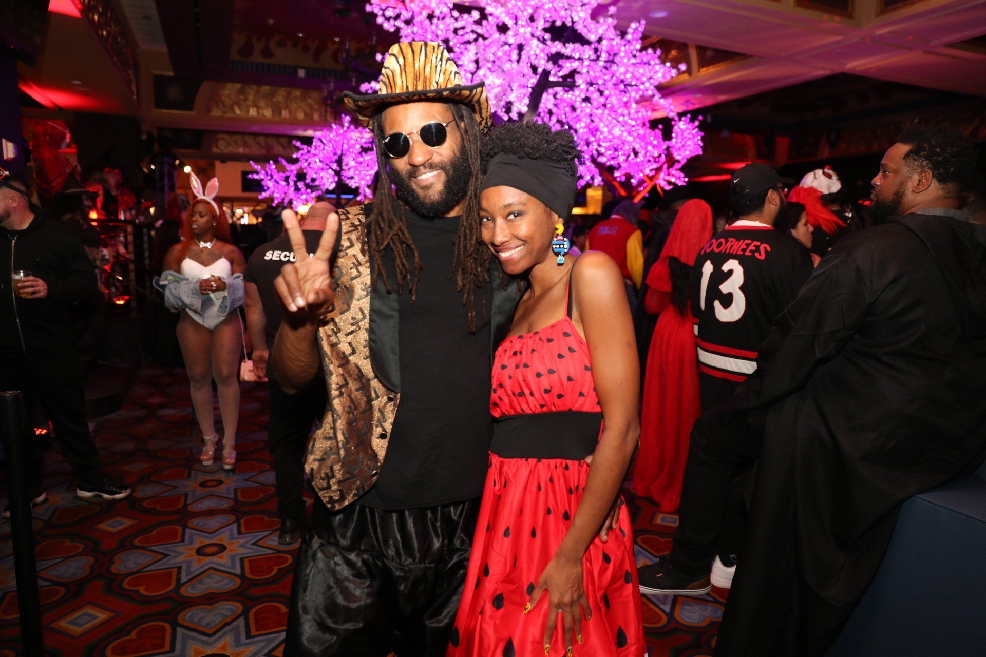 A man and a woman are posing for a picture at a party.