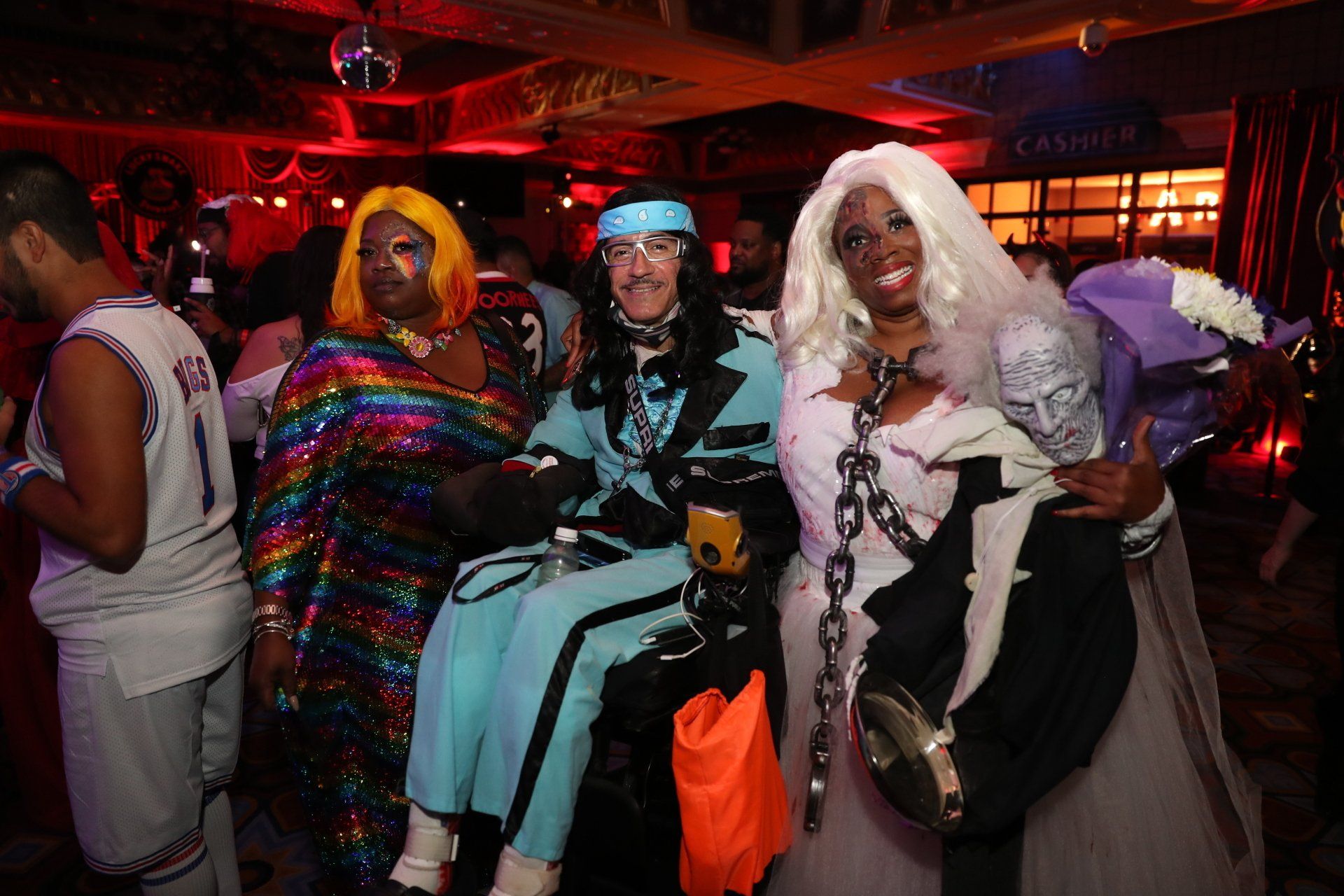A group of people dressed in costumes are posing for a picture at a party.