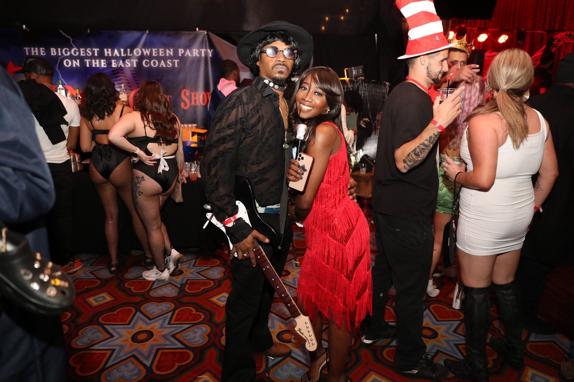 A group of people are standing in a room at a halloween party.