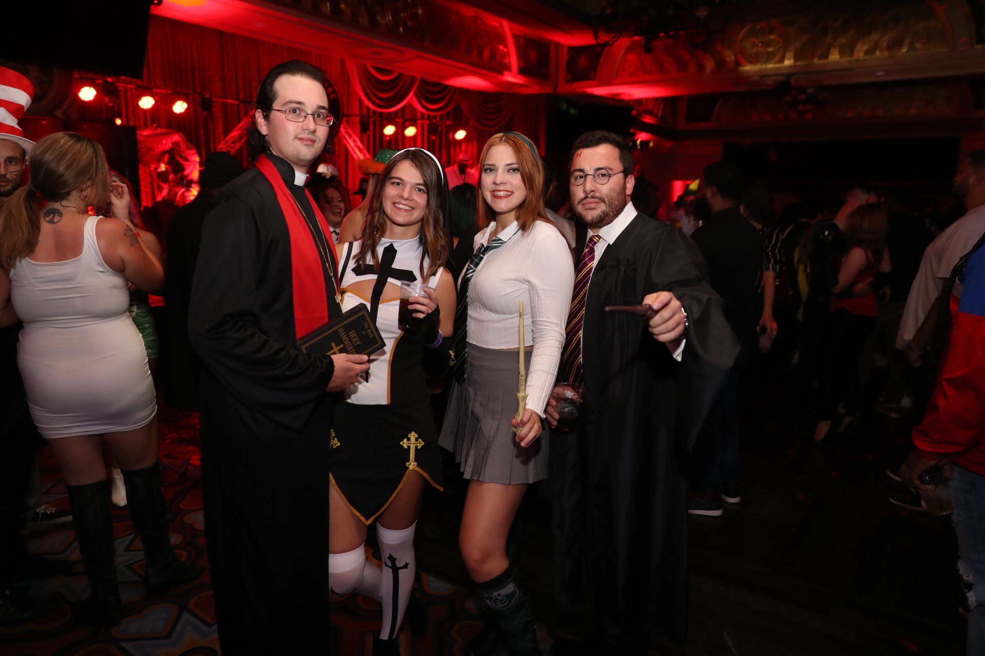 A group of people dressed in costumes are posing for a picture at a halloween party.