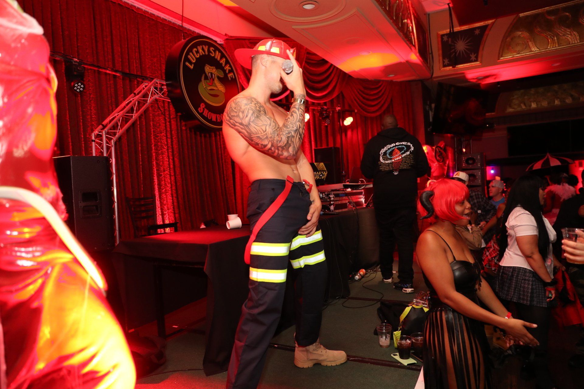 A man in a fireman costume is singing into a microphone