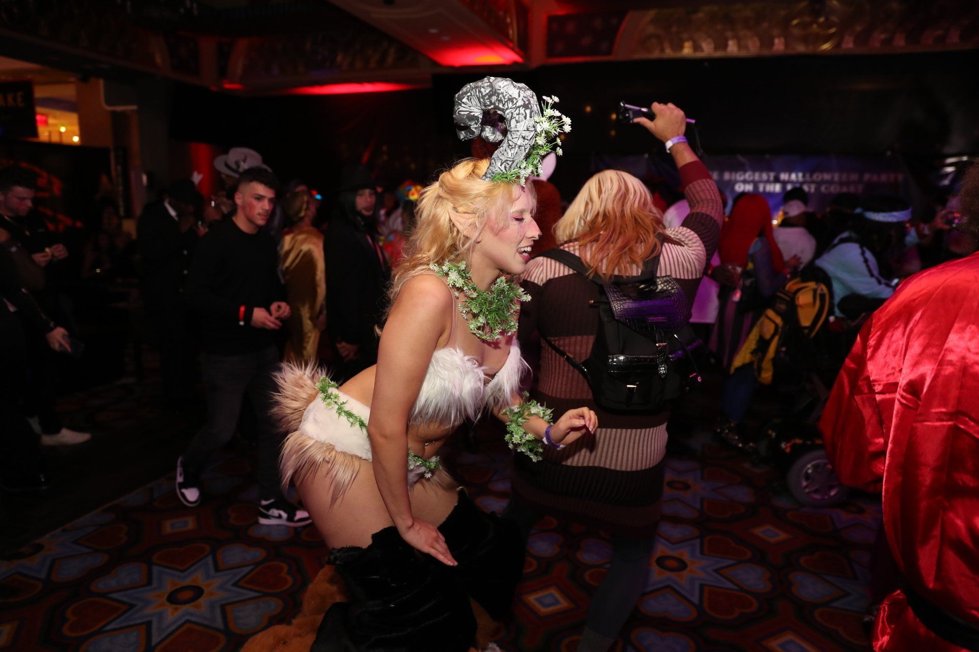 A woman in a costume is dancing in a crowded room