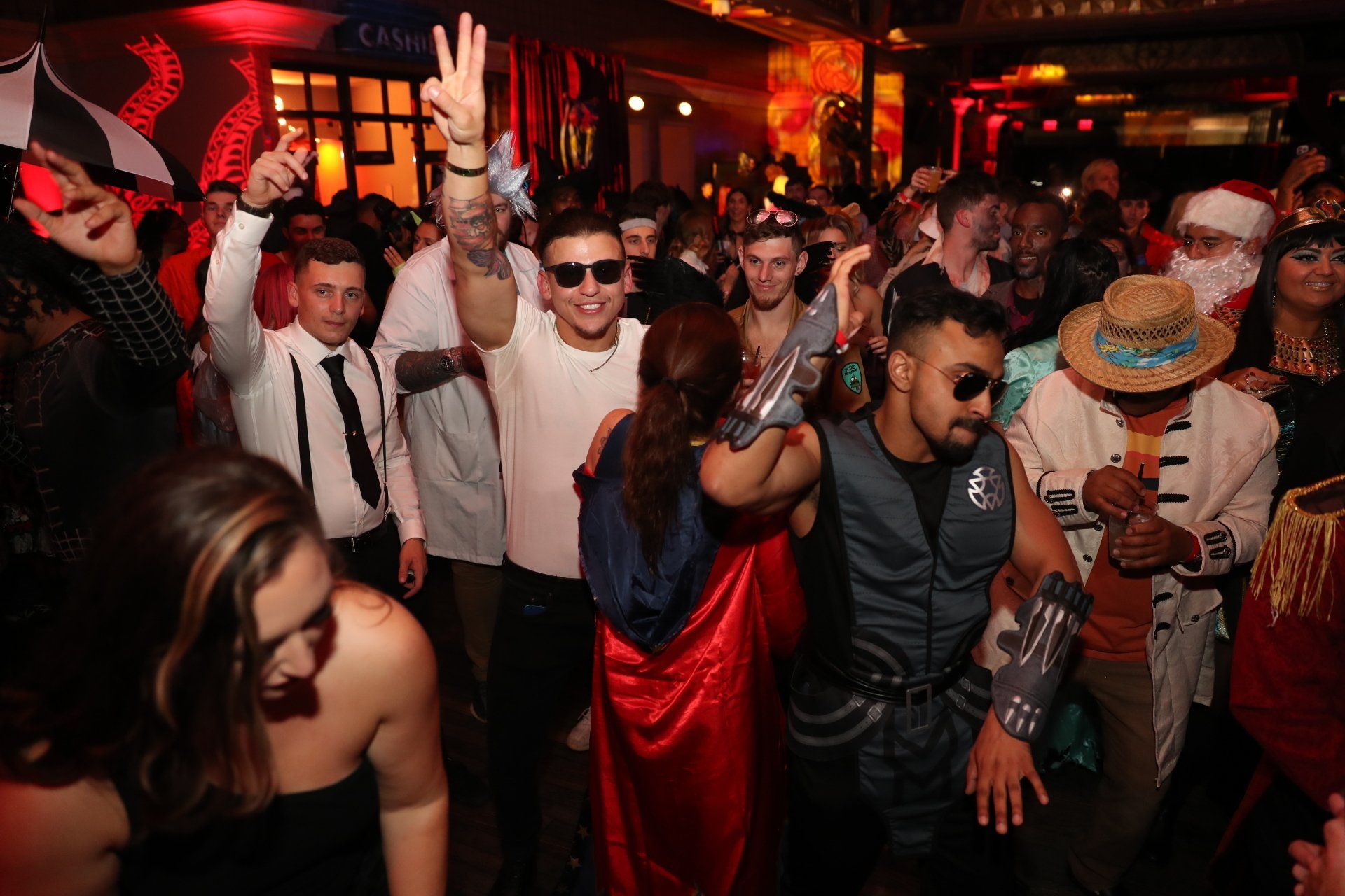 A group of people dressed in costumes are dancing at a party.