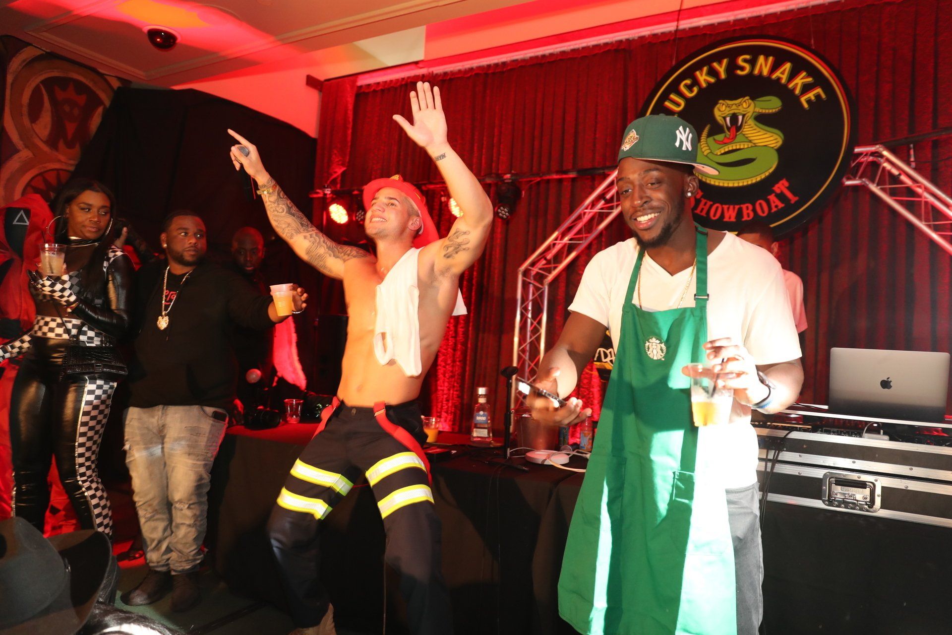 A group of men are standing on a stage in front of a sign that says lucky snake