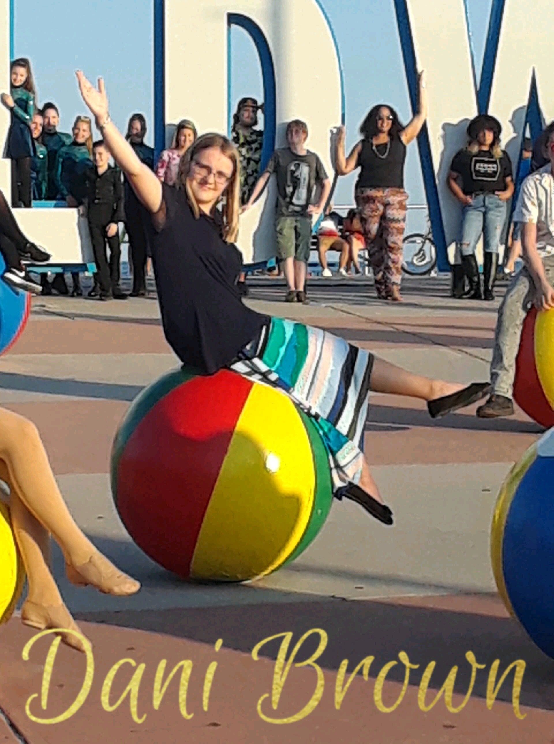 Dani brown is sitting on a beach ball