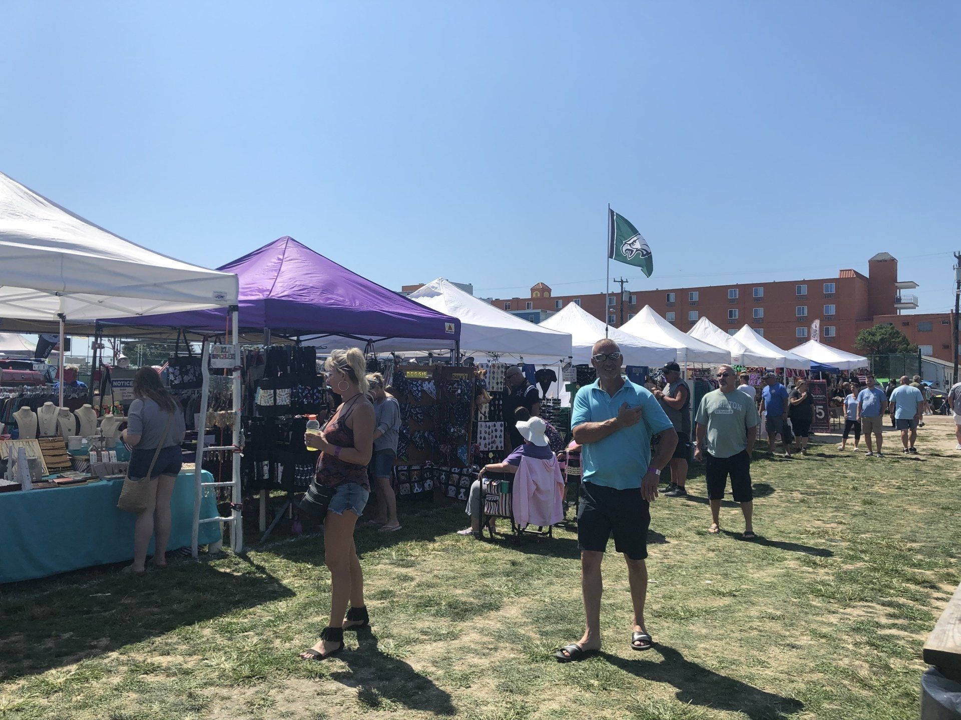 A group of people are standing in a field at a market.