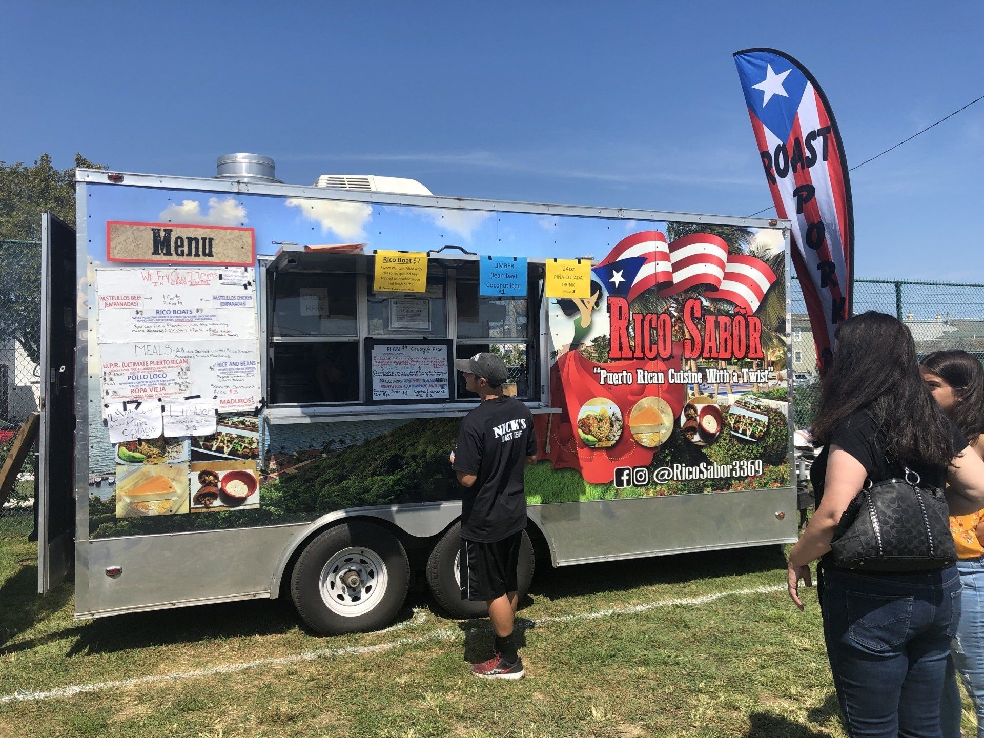 A man is standing in front of a food truck.
