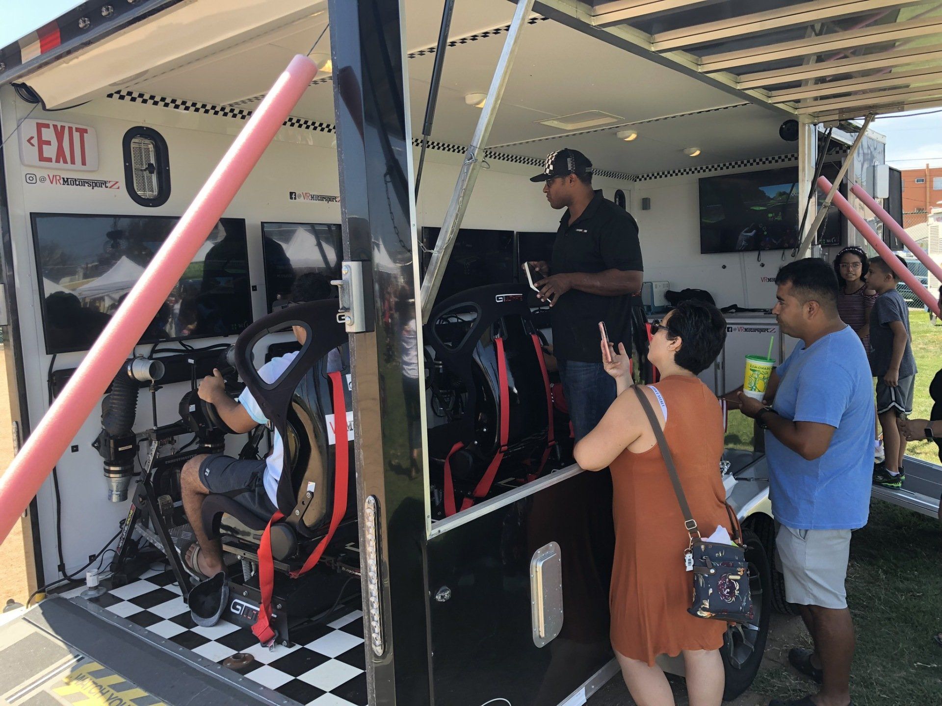 A group of people are standing outside of a trailer.