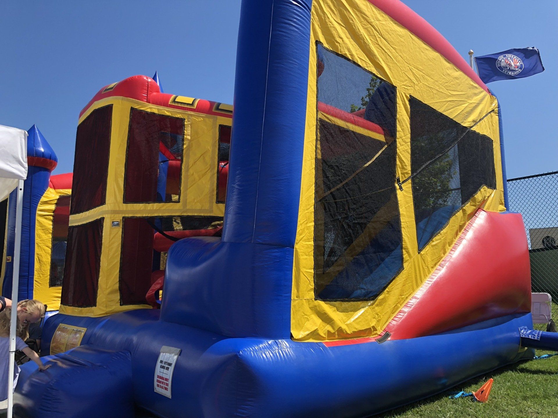 A colorful bouncy house is sitting on top of a lush green field.