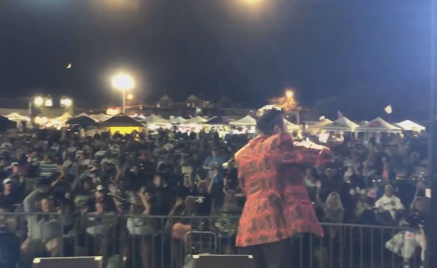 A man is standing on a stage in front of a crowd of people.