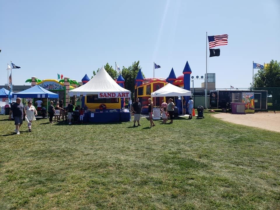 A group of people are walking through a grassy field.