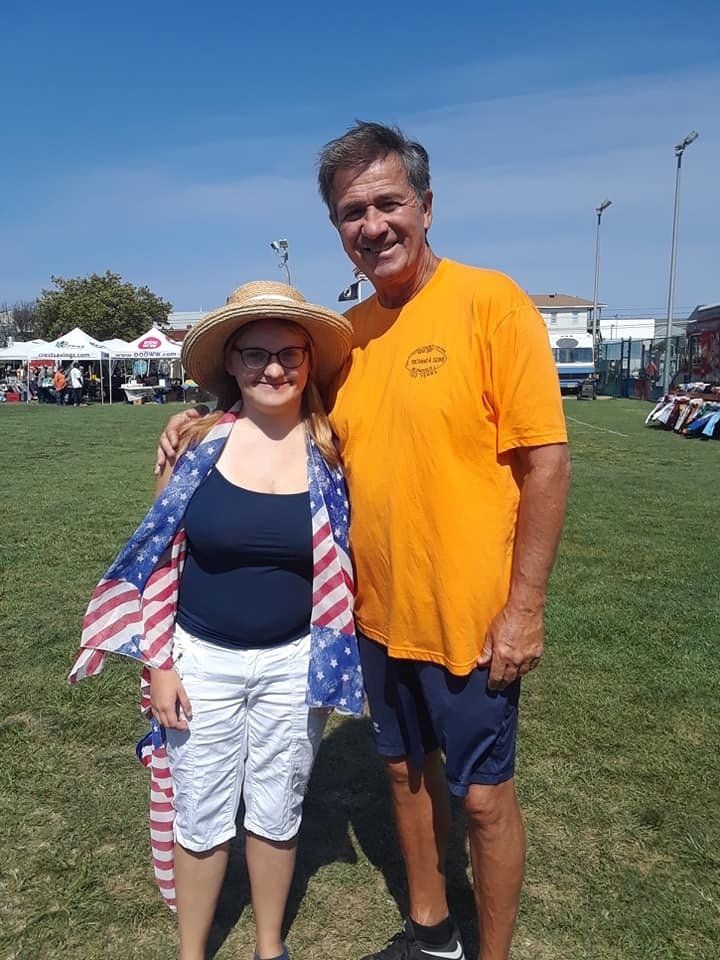 A man and a woman are posing for a picture in a field
