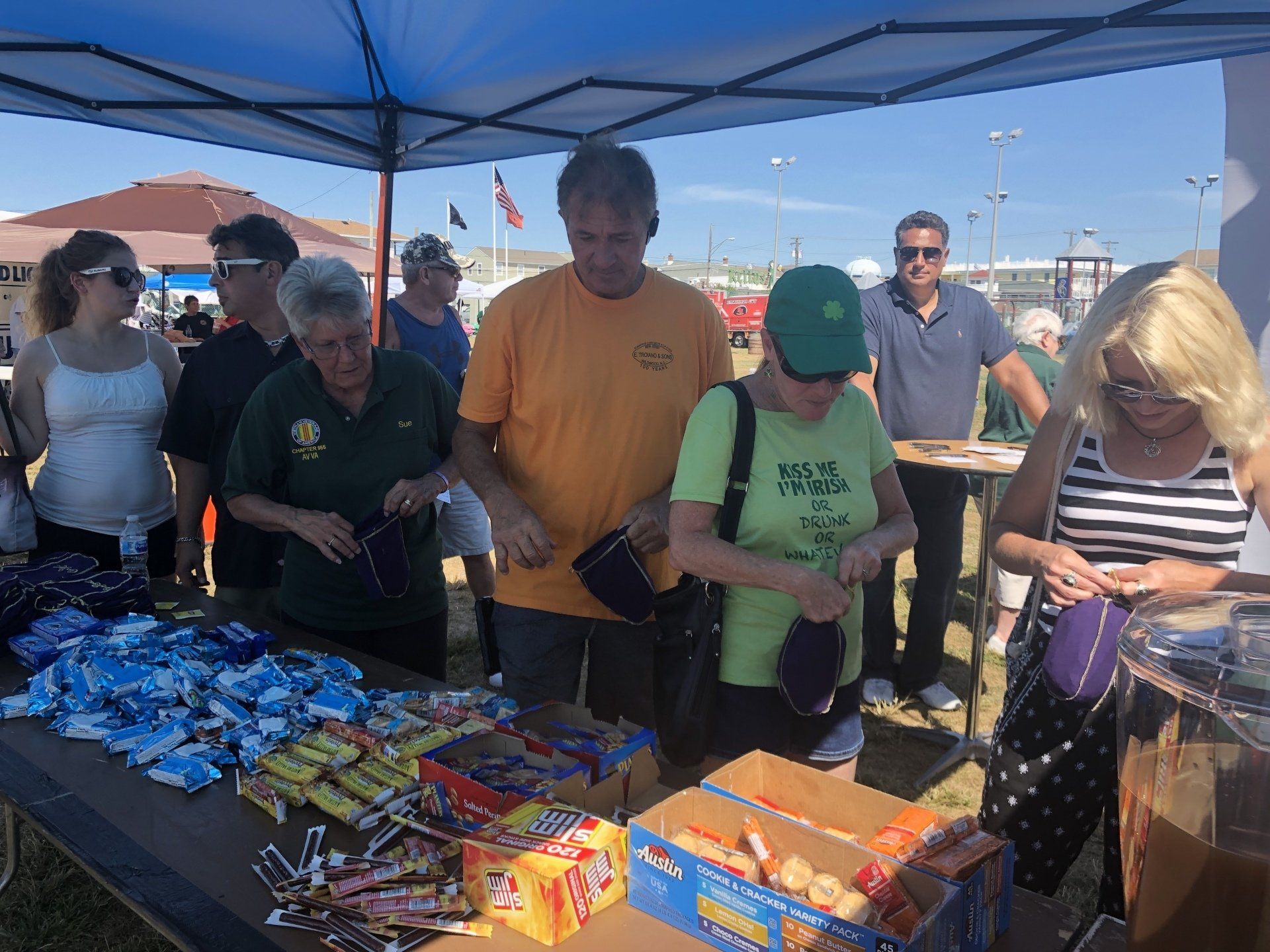 A group of people are standing around a table with candy on it