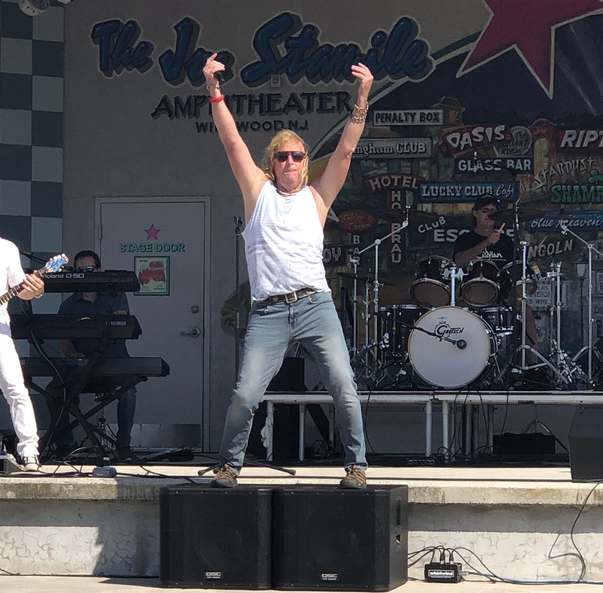 A man stands on a stage with his arms in the air