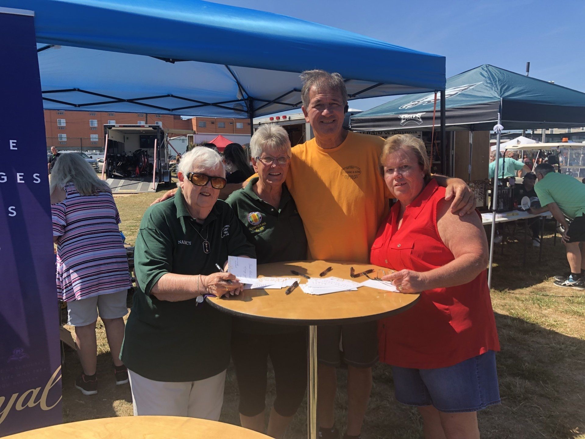 A group of people are posing for a picture in front of a tent.