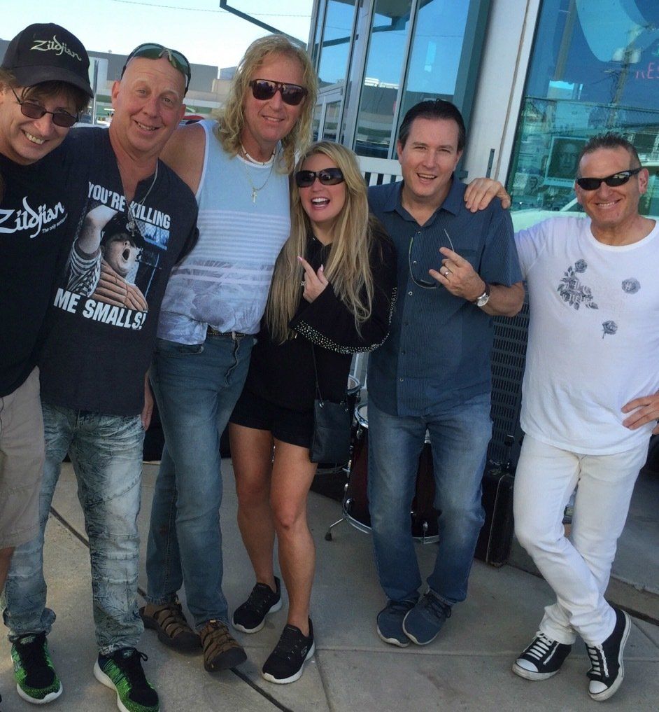 A group of people posing for a picture with one man wearing a shirt that says ' zildjian ' on it