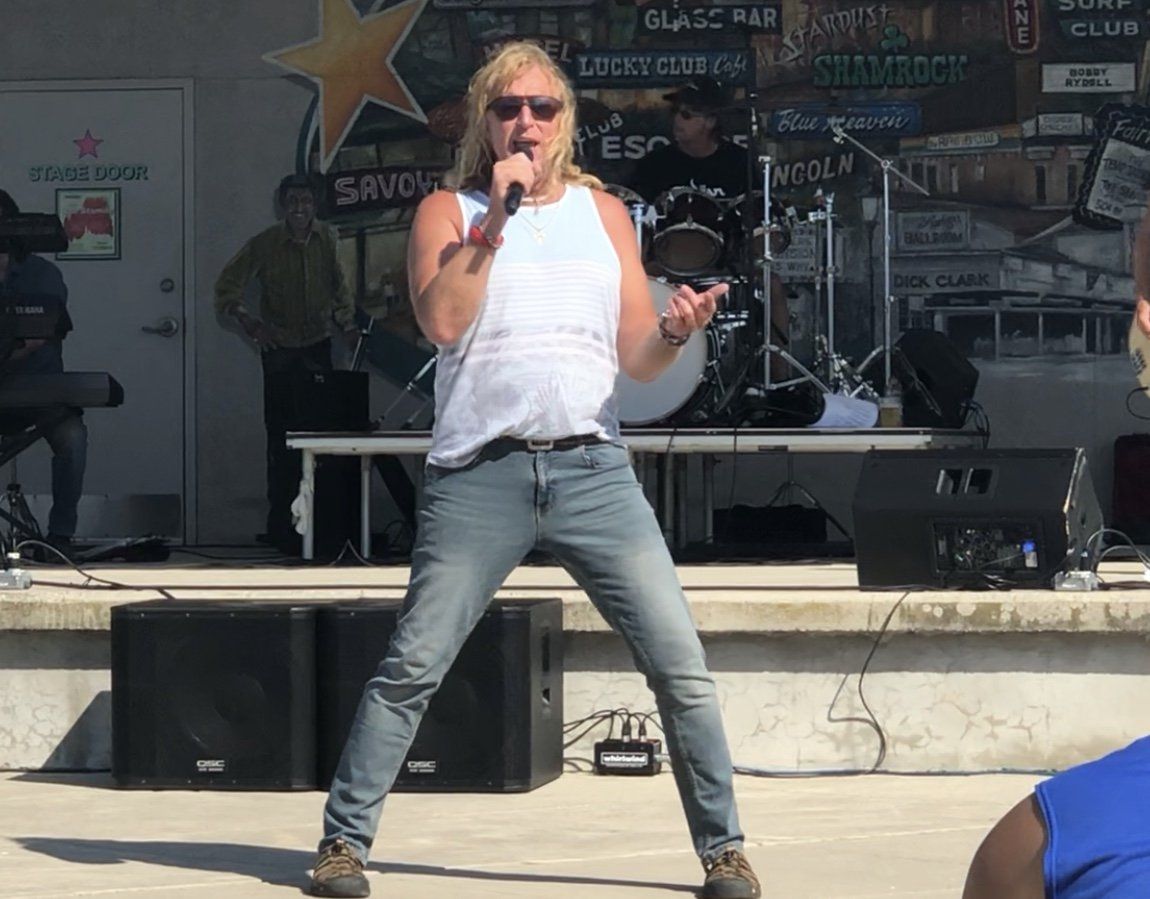 A man singing into a microphone on a stage