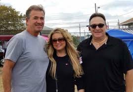Two men and a woman are posing for a picture together.