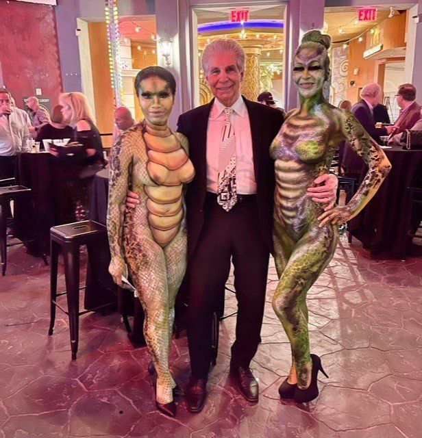 A man and two women are posing for a picture in front of an exit sign