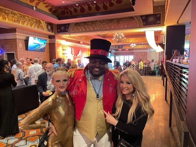 A man in a top hat is posing for a picture with two women.