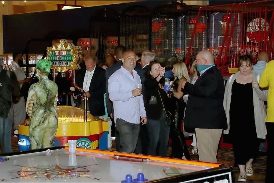 A group of people are standing around an air hockey table