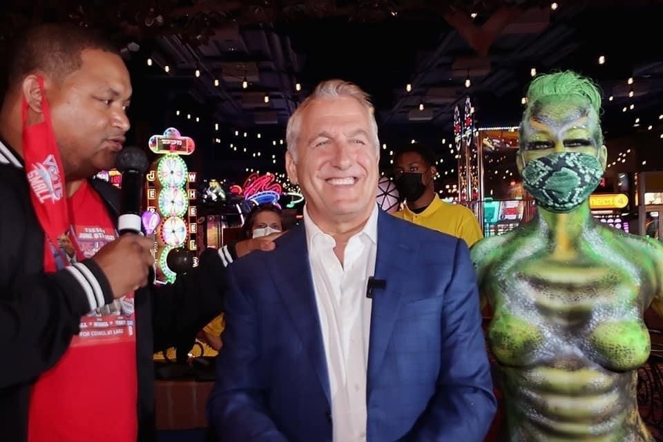 A man in a suit is standing next to a body painted woman