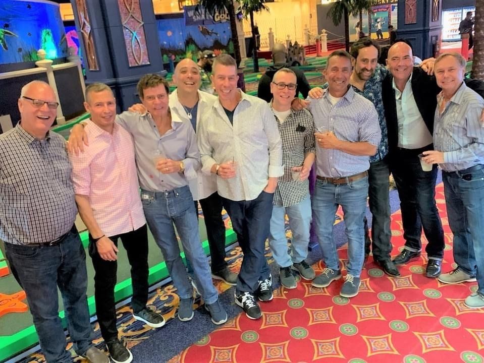 A group of men are posing for a picture together in a room.