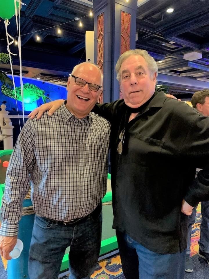 Two men are posing for a picture together in a room.