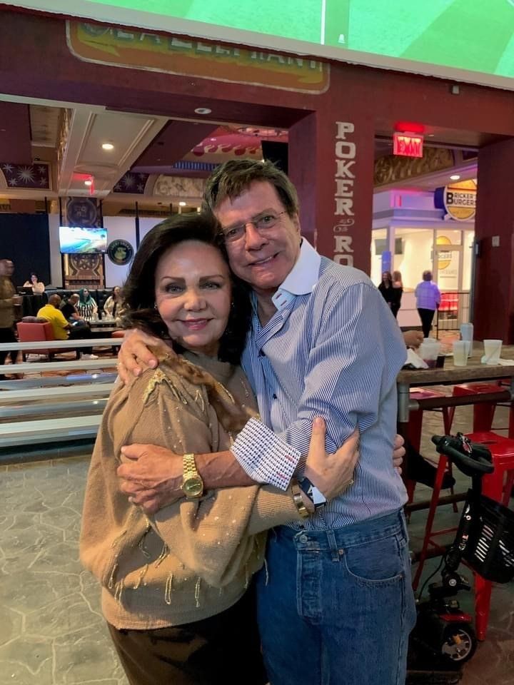 A man and a woman are hugging each other in a restaurant.