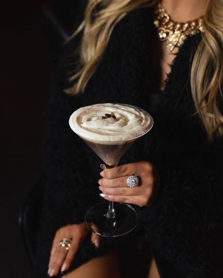 Woman holding a craft espresso martini cocktail at Aura HiFi lounge