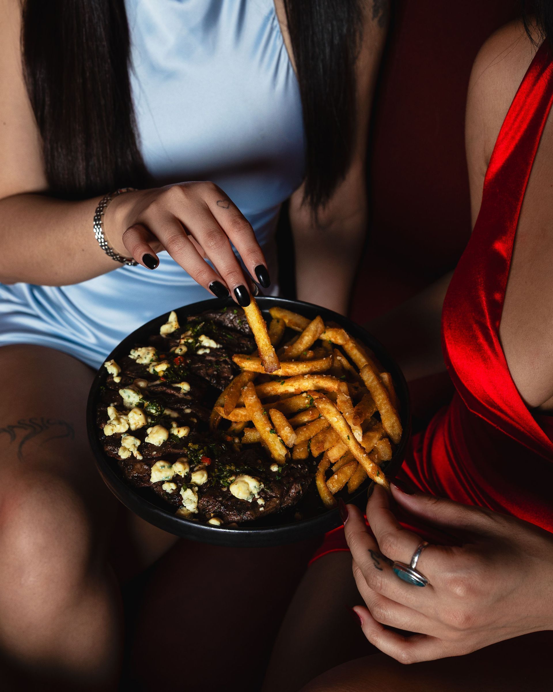 Guests sharing steak and fries at Aura HiFi