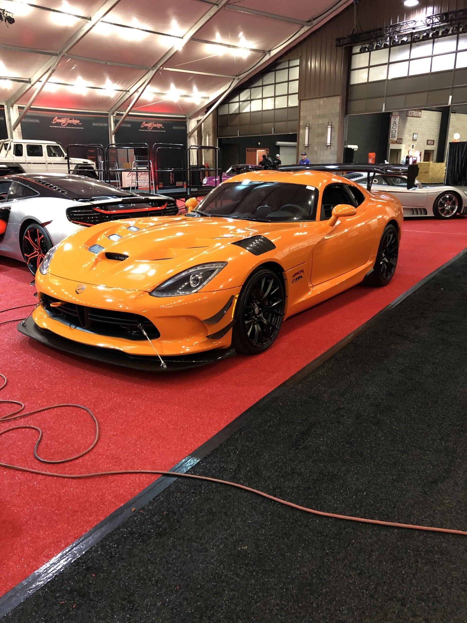 a yellow sports car parked on a red carpet car show .