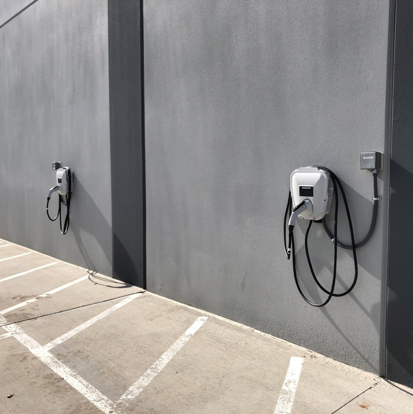 two electric vehicle charging stations on the side of a building
