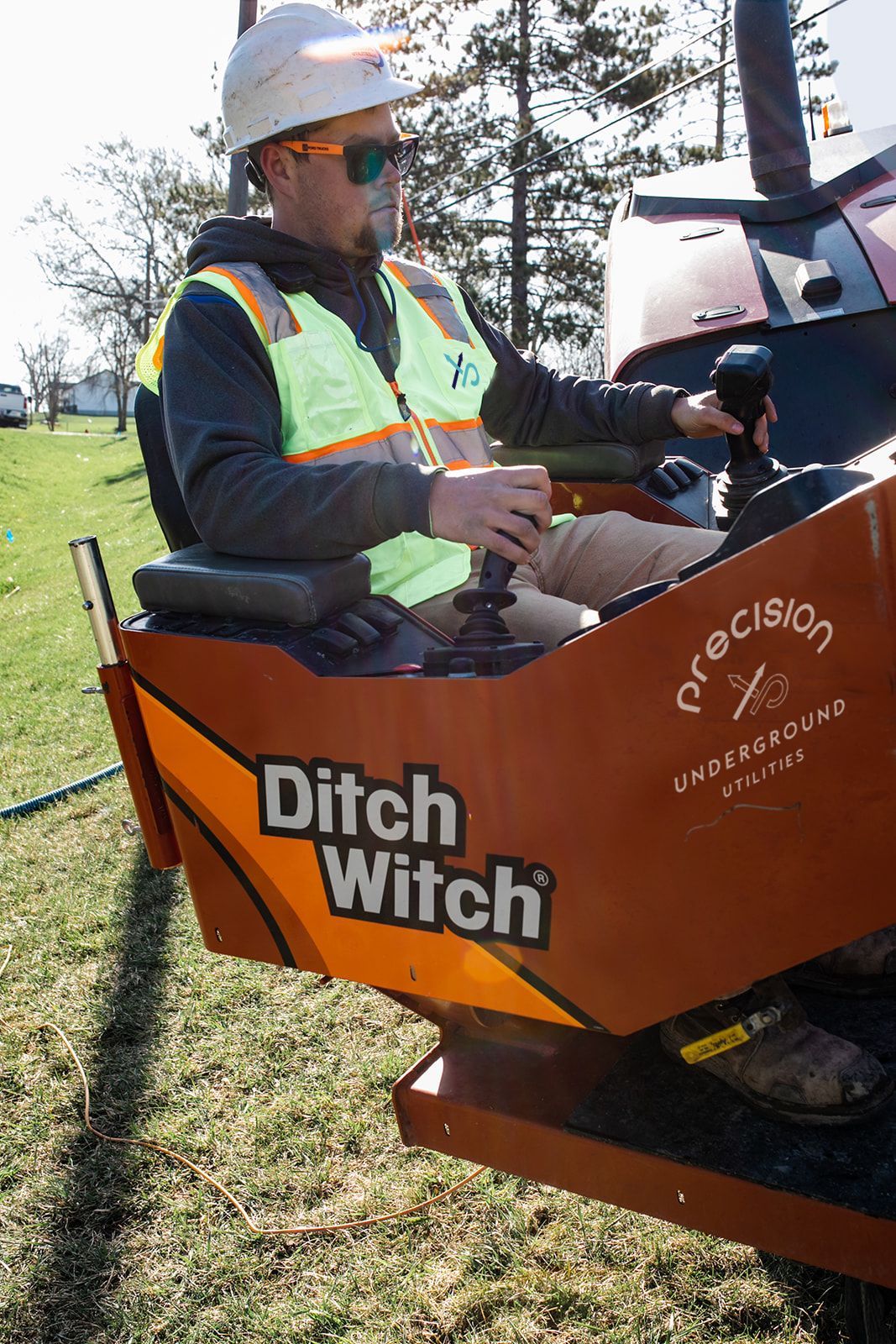 Utility workers using a ditch witch