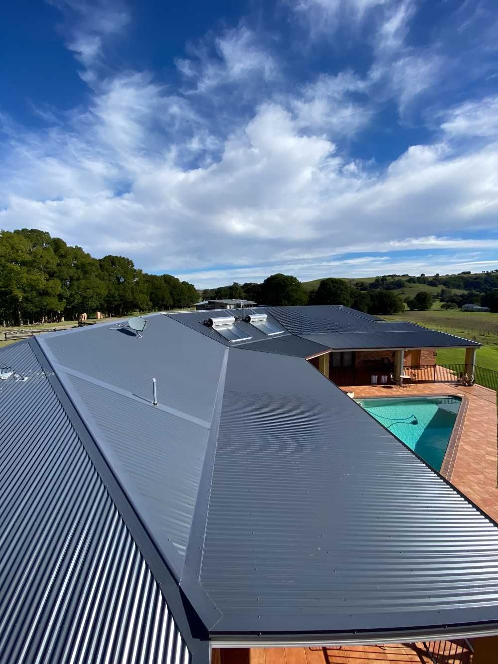 An Aerial View Of A House With A New Grey Roof And A Pool — Southern Cross Roof Plumbing in Bangalow, NSW
