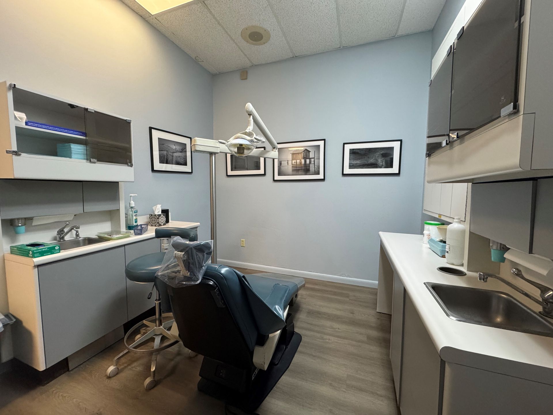 A dentist is talking to a woman and a child in a dental chair.