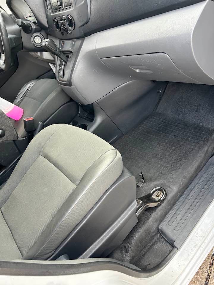 The inside of a car with a spray bottle in it.