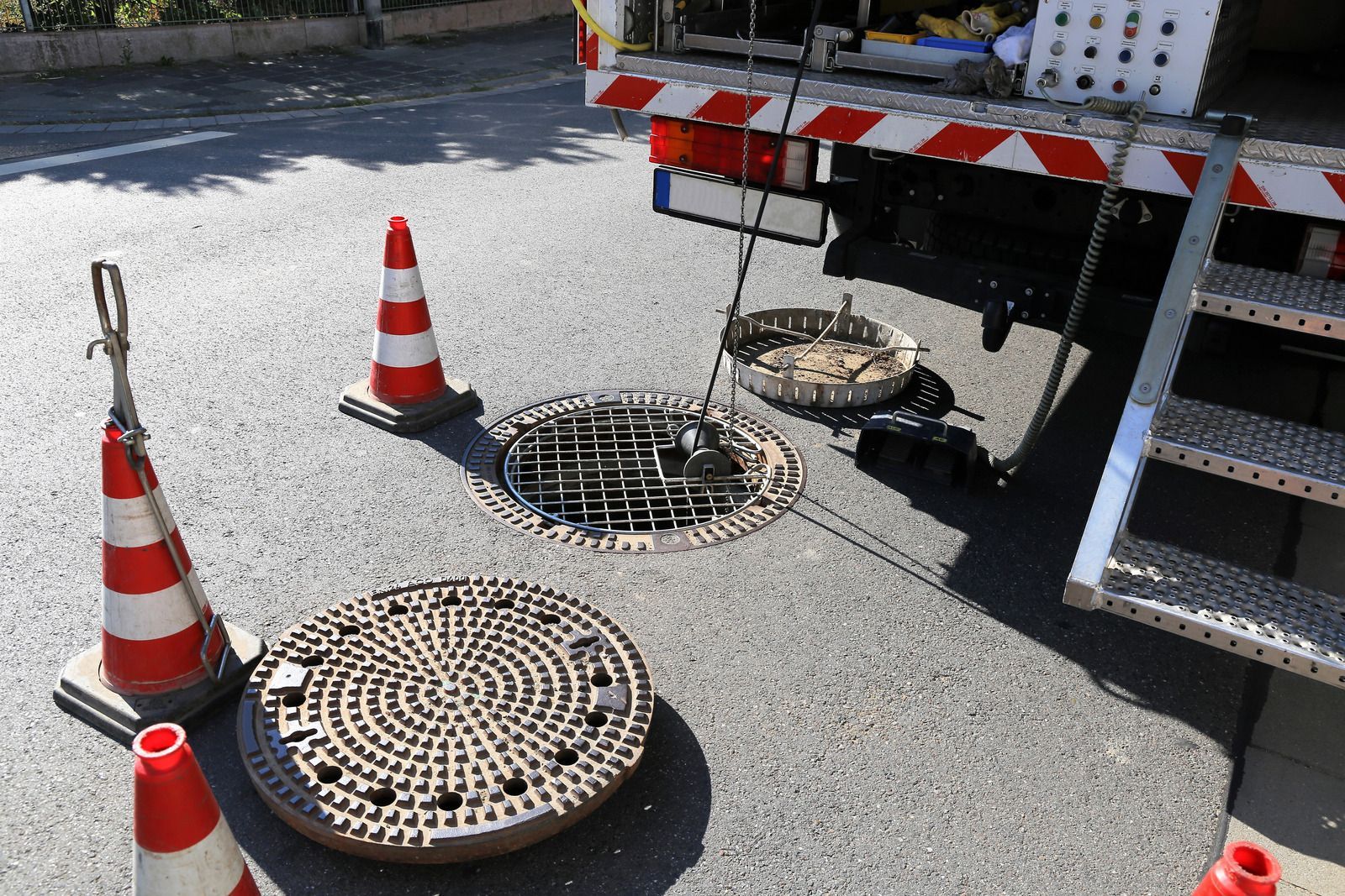A manhole cover is sitting on the ground next to a truck.