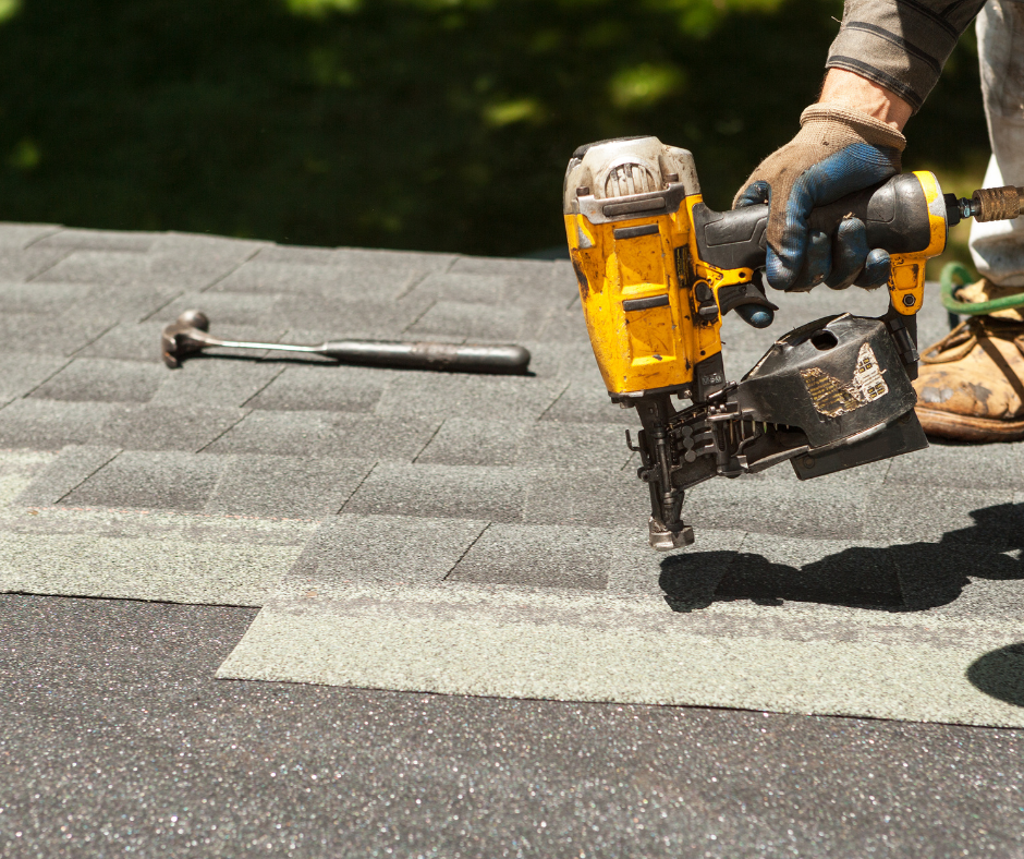 A person holding a driller fixing a roof