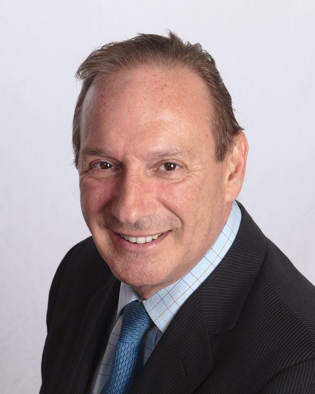 A man in a suit and tie is smiling for the camera.