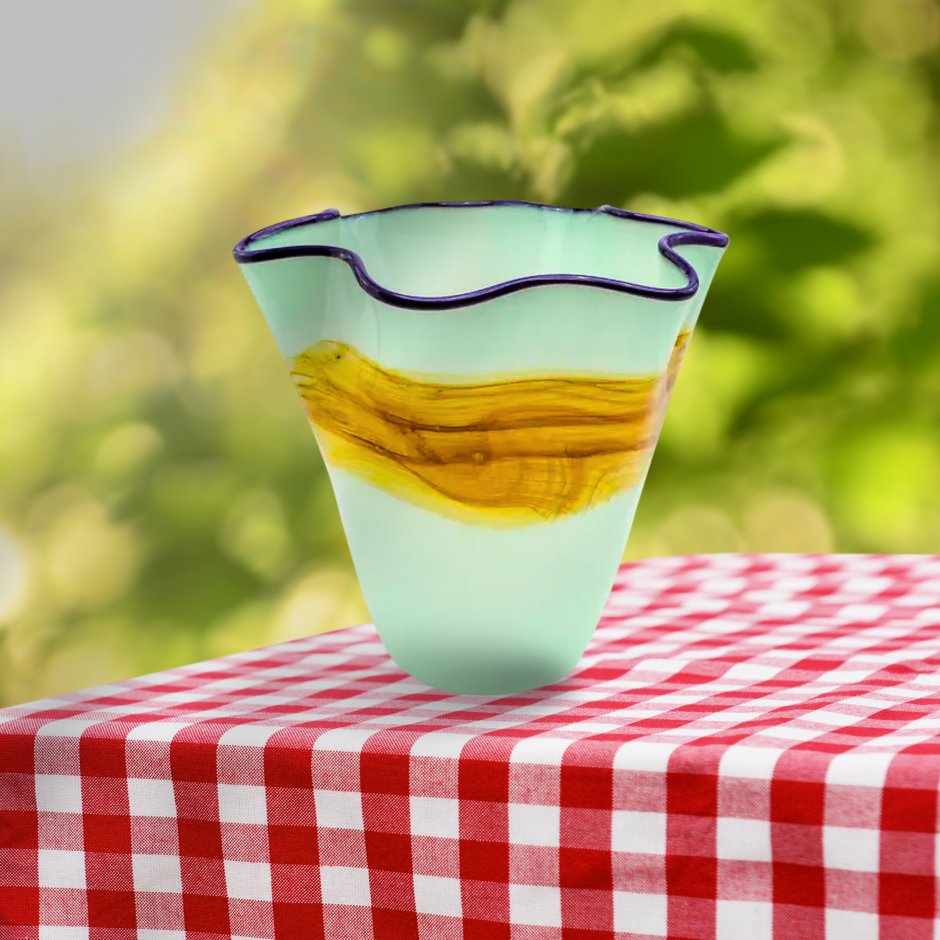 A glass vase is sitting on a checkered table cloth