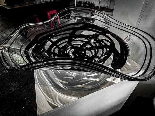 A black and white photo of a glass bowl sitting on top of a table.