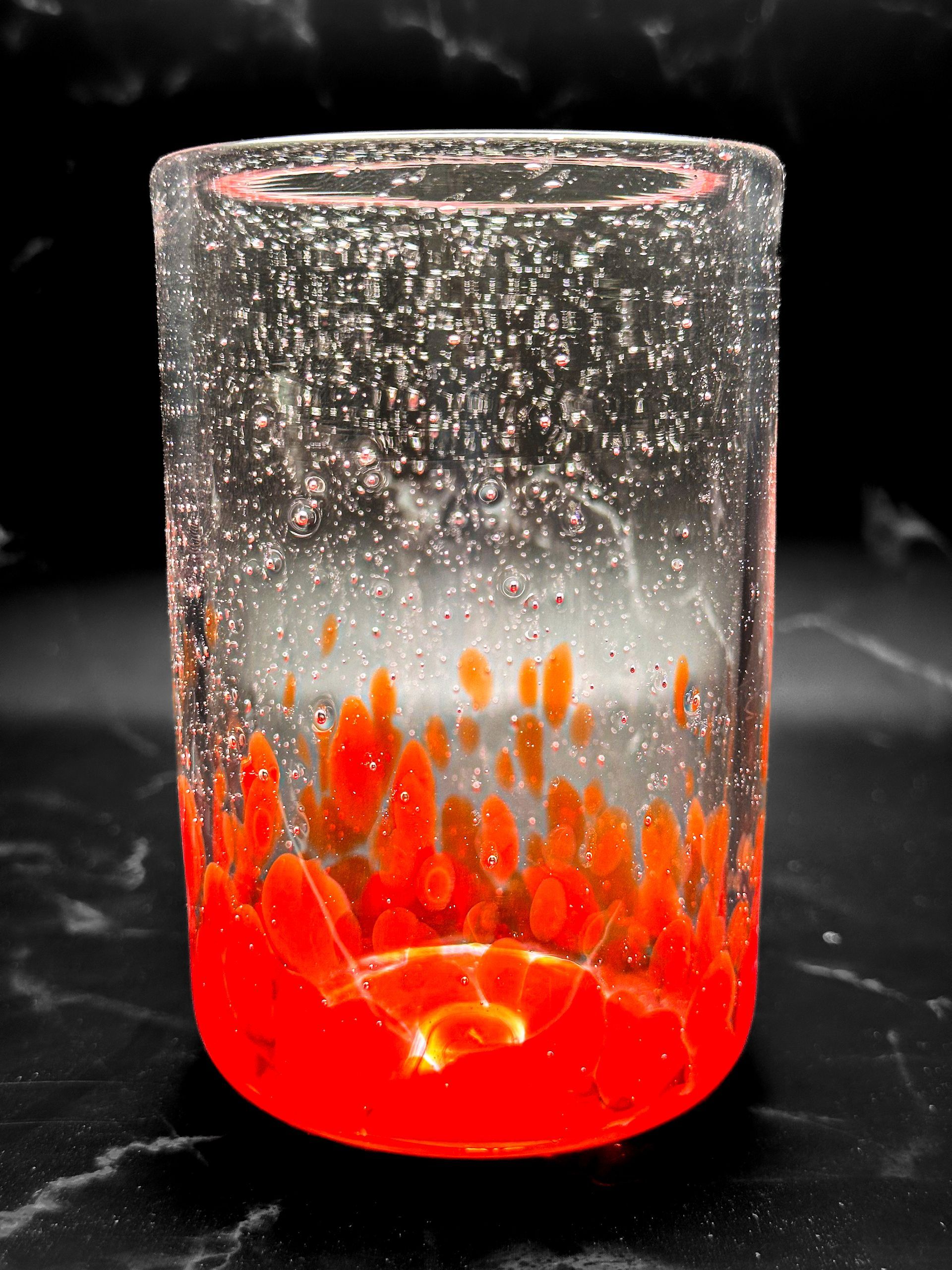 A glass filled with red liquid is sitting on a table.