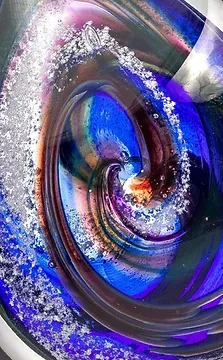 A close up of a blue and purple swirl in a glass bowl.