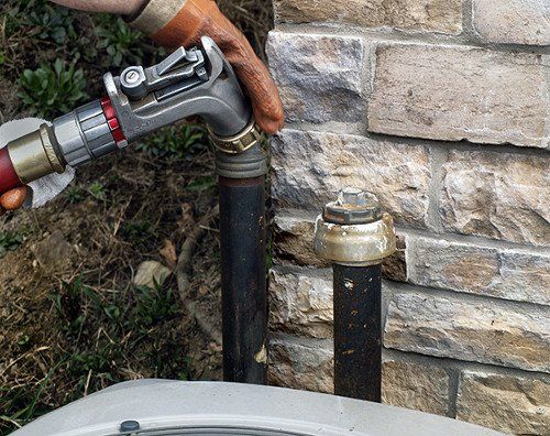 A person is pumping gas into a hose.