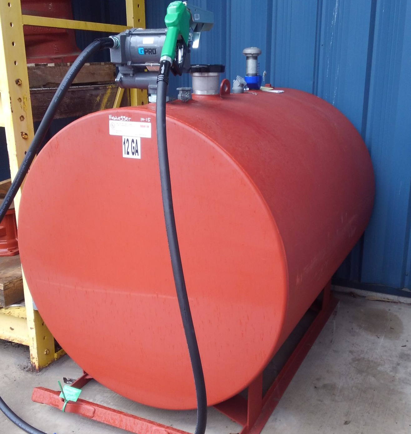 A table with a bottle and glasses on it in front of a window