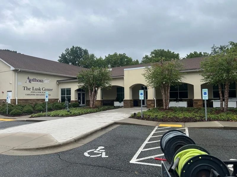 Exterior view of The Link Center, a building with accessible parking and a ramp, under a cloudy sky.